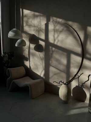 a room with a chair, lamp, and a sculpture